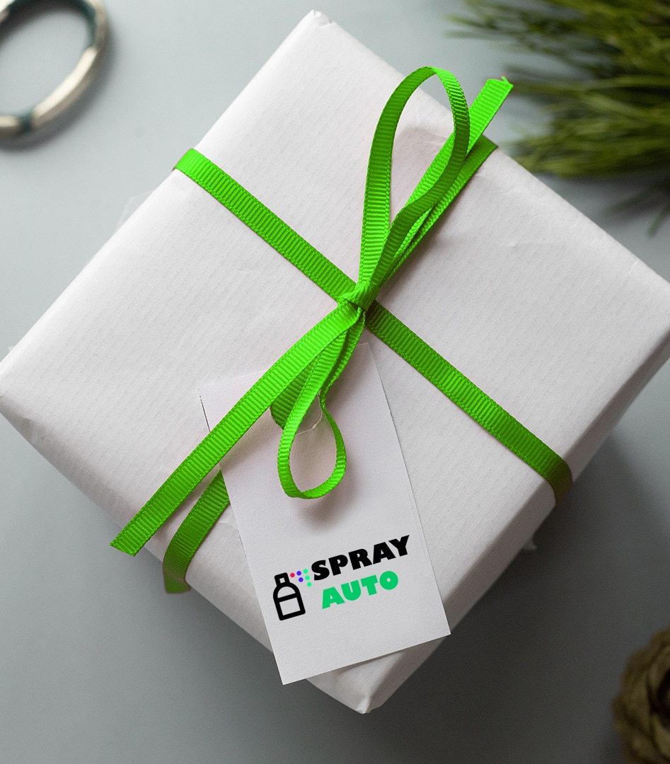 Cadou ambalat în hârtie albă cu panglică verde și etichetă Spray Auto